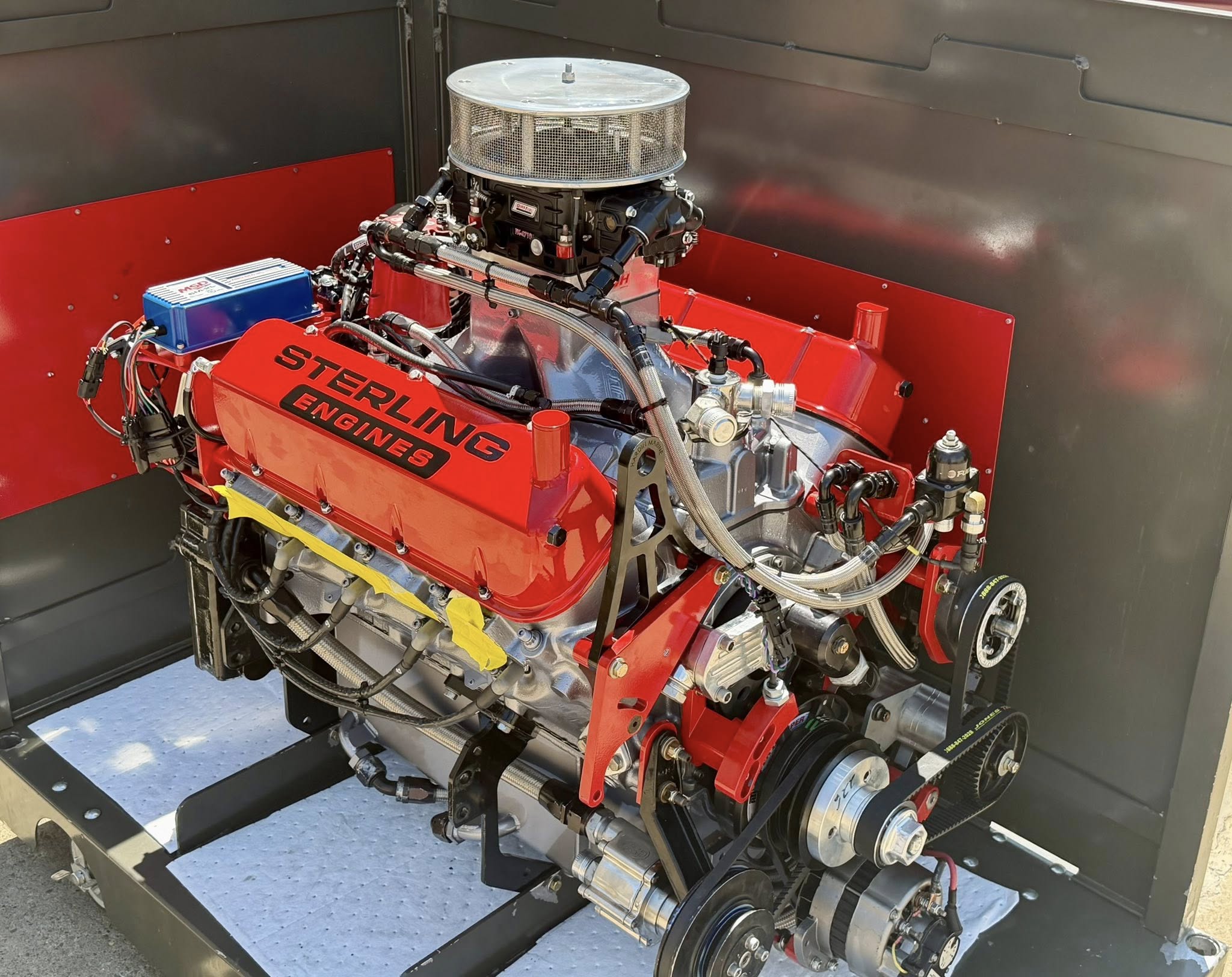 Red Sterling Engines crate auto engine on a stand, branded valve covers and polished intake