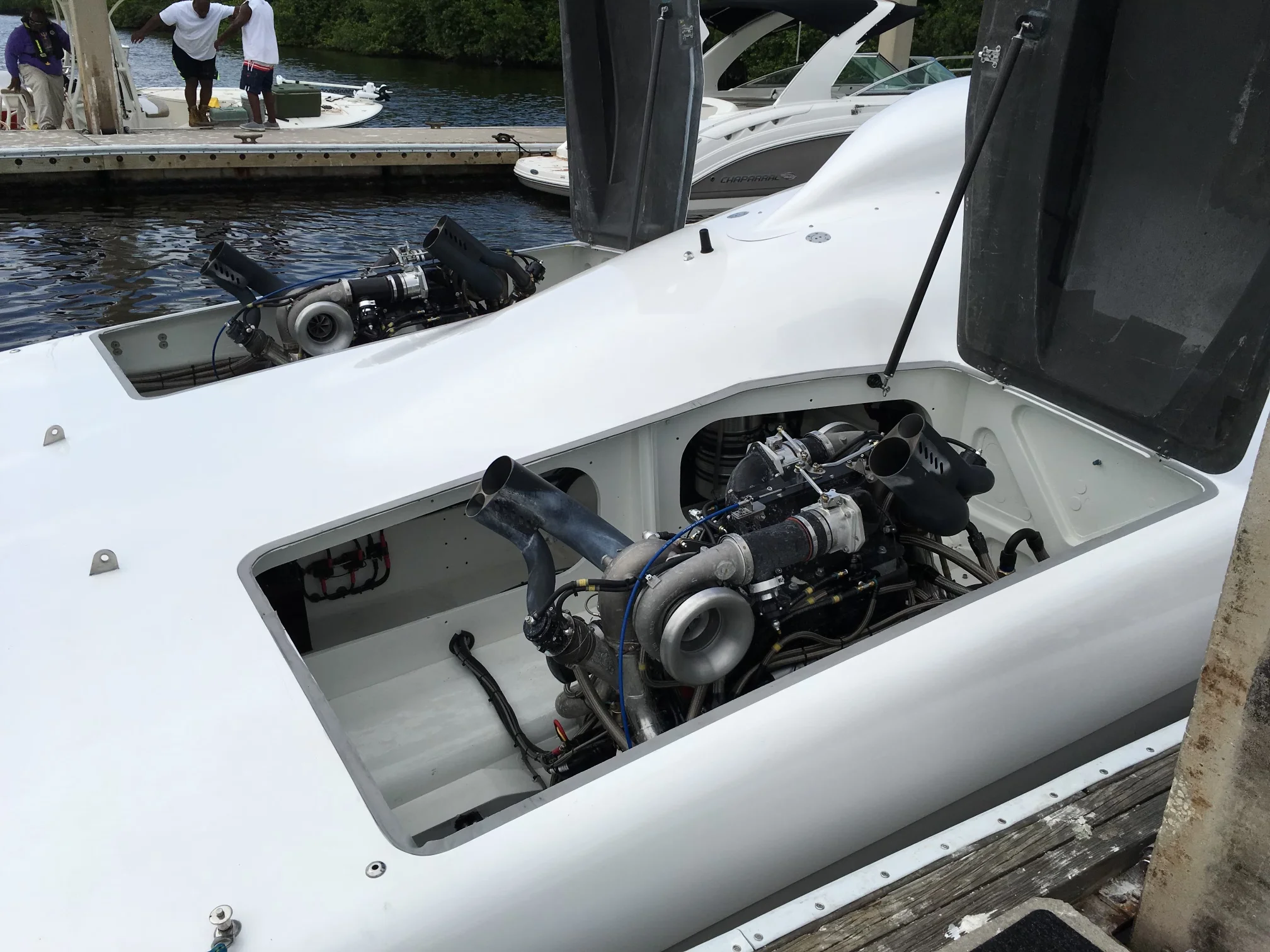 Twin turbocharged Sterling marine engines in an open engine bay of a performance catamaran at the dock